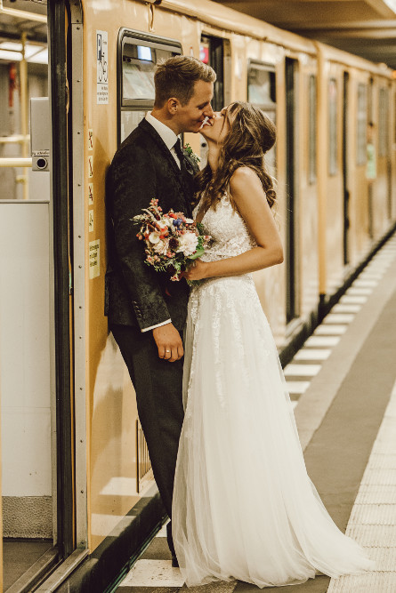 Verliebtes Brautpaar küsst sich vor einer U-Bahn