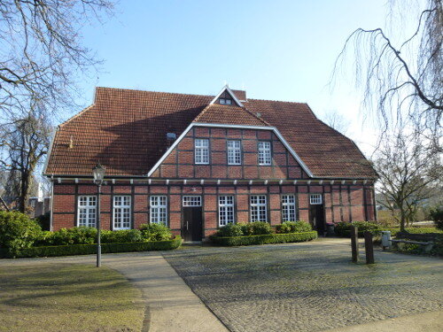 Frontalansicht auf das historische Fachwerkgebäude Hof Deitmar, welches mit Ziegelsteinen und klassischen Sprossenfenstern gebaut wurde